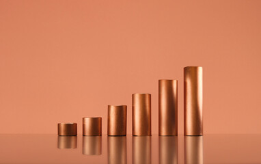 Copper tubes forming a growing bar graph, copy space. Trading and commodity supercycle concept,...