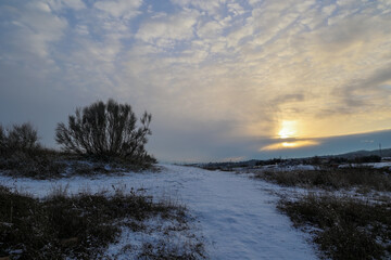 Fototapeta na wymiar Atardecer nevado y puesta de sol