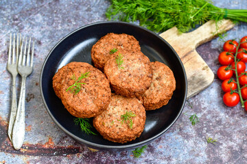 Home made  pork meatballs with  fresh cherry tomatoes on wooden rustic background. Deep fried minced  meat patties on cutting board.