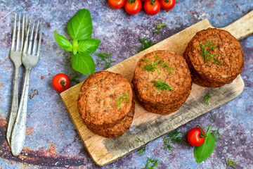 Home made  pork meatballs with  fresh cherry tomatoes on wooden rustic background. Deep fried minced  meat patties on cutting board.