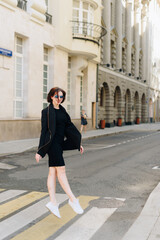 Beautiful woman in a black dress on a background of an urban landscape