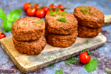 Home made  pork meatballs with  fresh cherry tomatoes on wooden rustic background. Deep fried minced  meat patties on cutting board.