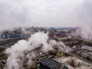 Obraz na płótnie Canvas Aerial drone view. The building of the Kiev railway station through the white smoke from the chimneys.