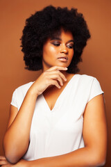 Fototapeta na wymiar pretty young african american woman with curly hair posing cheerful gesturing on brown background, lifestyle people concept