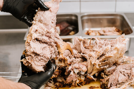 A chef preparing pulled pork meat. American traditional cuisine
