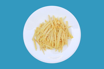 Sliced Ginger rhizome close up on white circle plate isolated on blue background with clipping path. Top view