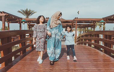 Mom and daughters spending time together at the park, in Dubai