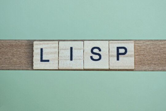 gray word lisp made of wooden square letters on green background