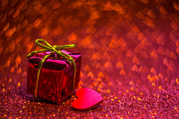 
gift and heart on red glittering background