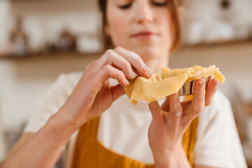 Caucasian focused pastry chef woman making tart at cozy kitchen