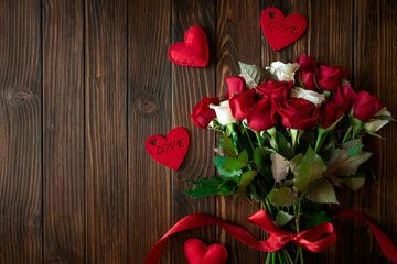 Red and white roses with hearts on wooden background. Valentines, mothers day and birthday celebration concept. Copy space. Top view.