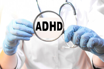 The doctor's blue - gloved hands show the word ADHD - . a gloved hand on a white background. Medical concept. the medicine
