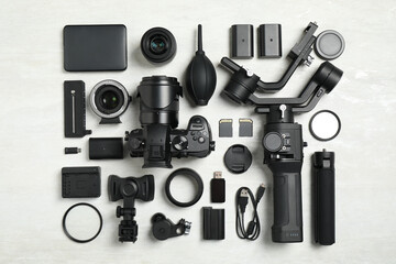 Flat lay composition with camera and video production equipment on light background