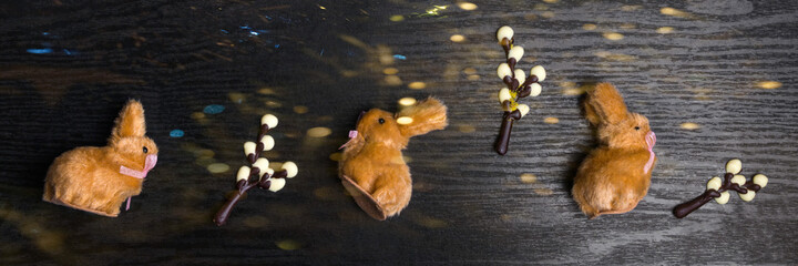 chocolate willow branches and cute bunnies on wooden background