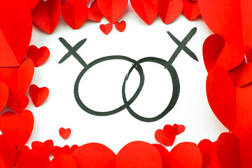 Valentine's Day background. Red paper hearts are lined along the edge against a white background with an ink drawing of the signs of venus. Woman signs. Lesbian couple.