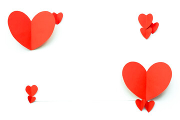 Valentine's Day background. Red paper hearts are laid out in four dots on a white background with space for text. Bright colorful hearts for postcards.
