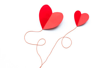 Valentine's Day background. Red paper hearts connected by a thread on a white background, isolated. - 404883572