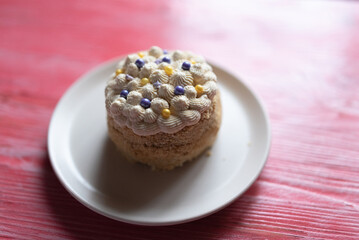 Homemade sponge cake on a pink wooden background.