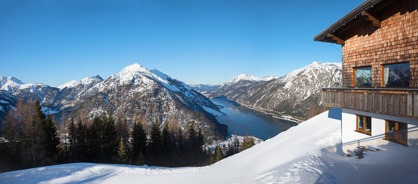 lookout from Zwolferkopf mountain to lake achensee and tirolean alps in winter, restaurant at the summit