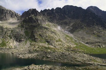 Panoramic view to a beautiful mountain lake and impressive high mountain range in the Tatra mountains.