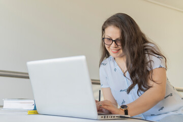 Mujer sonriendo mientras trabaja con su laptop en casa. Concepto trabajo y estudio en cuarentena