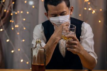 Business man Holding a glass whiskey wearing protective mask on the office