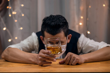 Barman pouring whiskey wearing  protective mask on the bar counter 