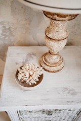 white coral in cup on bedside table.rare mineral from bottom of sea, which is fossilized part of polyps. jewelry with it is exquisite, but fragile. interior decor.narrow depth of field.selective focus