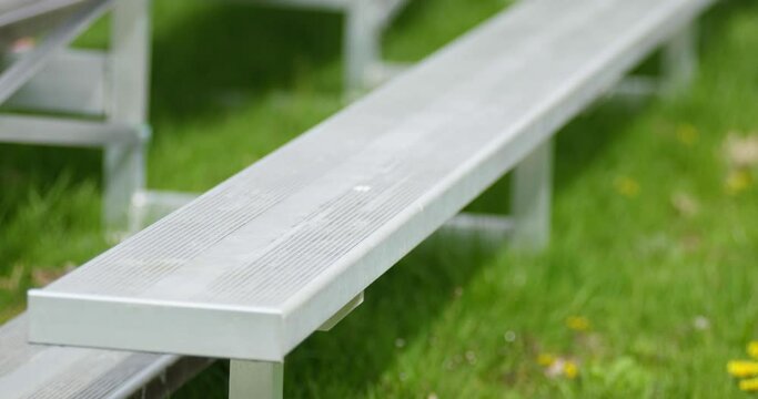 Empty School Metal and Steel Bleachers, Benches, and Seats with No People or Pedestrians on Grass Lawn
