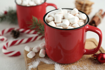 Obraz na płótnie Canvas Hot drink with marshmallows in red cup on white table