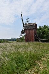 Fototapeta na wymiar Green landscape with an old wooden windmill
