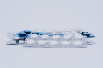 Pile of medicine pills in blister packs on white background. Medical treatment concept