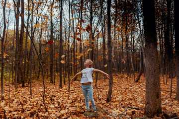 Fillette jouant dans les feuilles à l'automne