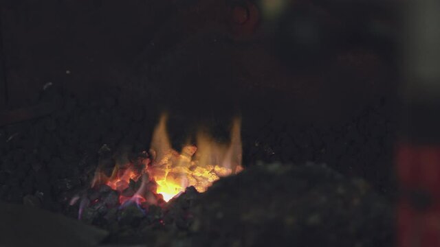 Close up of flames and blazing coals in blacksmiths forge - shot in slow motion
