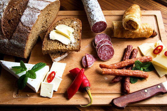 vesperplatte mit salami, cabanossi, verschiedenen k&auml;sesorten, gef&uuml;llten teigrollen und peperoni mit minzbl&auml;ttern