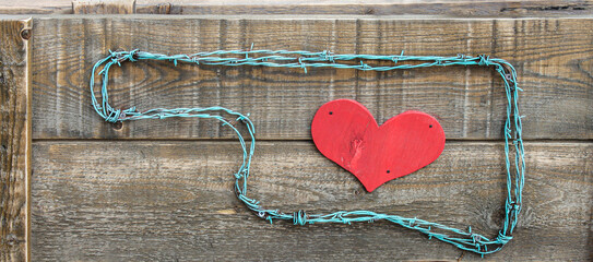 Rustic raw Love Oklahoma sign - barbed wire and wood rustic sign with red wooden heart inside Oklahoma shape on raw wooden planks - background or banner.