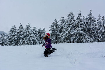happy girl child having fun, playing at winter walk outdoors