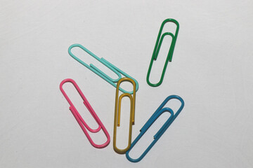 Paper clips. White background. Office supplies. Isolated colored paper clips on a white background