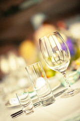 Glass pile, glass highbowl and wine glass on the background of a decorated served table for celebrating the holiday
