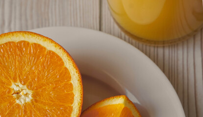 Fototapeta na wymiar Slices of oranges next to a bottle of fresh orange juice for breakfast