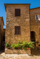 Obraz na płótnie Canvas An historic stone residential building in the village of Montemerano near Manciano in Grosseto province, Tuscany, Italy 