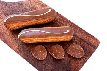 Traditional French Dessert. Two Chocolate Eclairs Glazed Kitchen Wooden Board. Milk Belgian...
