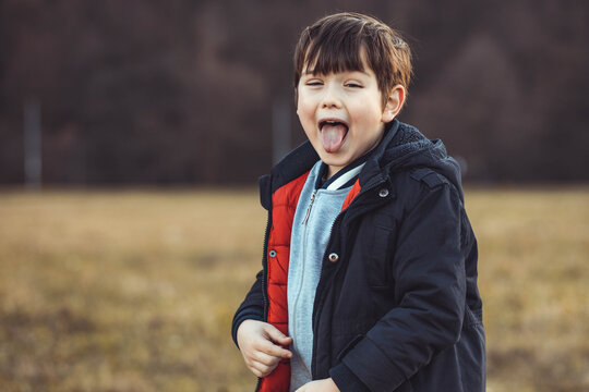 Portrait of a cute, little boy sticking out his tongue