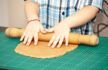 Little boy swinging a rolling pin cookie dough
