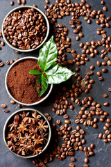 Coffee beans, milled coffee and spices on dark background