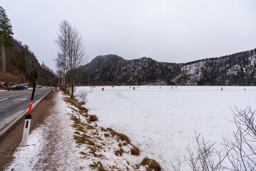 Eisstock Spieler und Eisläufer auf dem zugefrorenen Almsee in Oberösterreich