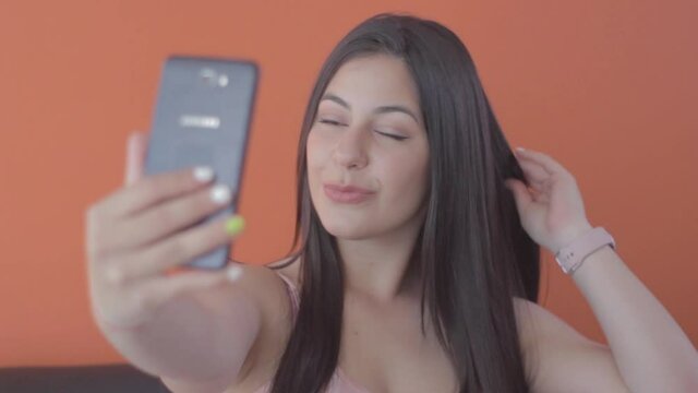 Chica se tom&aacute;ndose un selfie con su celular 