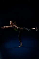 Fototapeta na wymiar young woman doing yoga taking a position on one leg