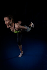 Fototapeta na wymiar girl doing yoga standing on one leg bend