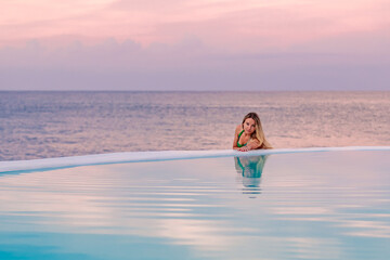 Young girl at dawn by the sea pool, calm and relaxed